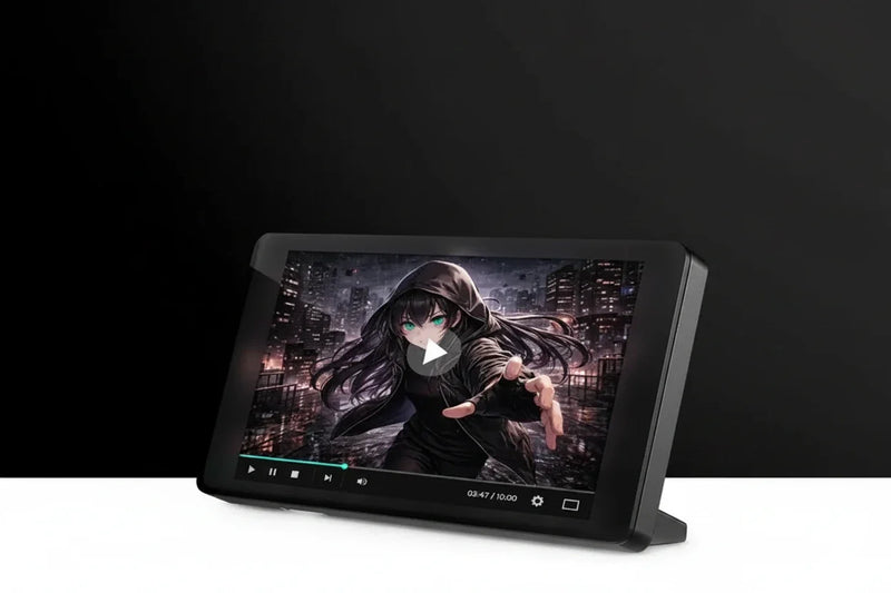 A black rectangular digital display or monitor on a stand, angled slightly to the side, showing a video player with an anime character on the screen against a dark studio background.